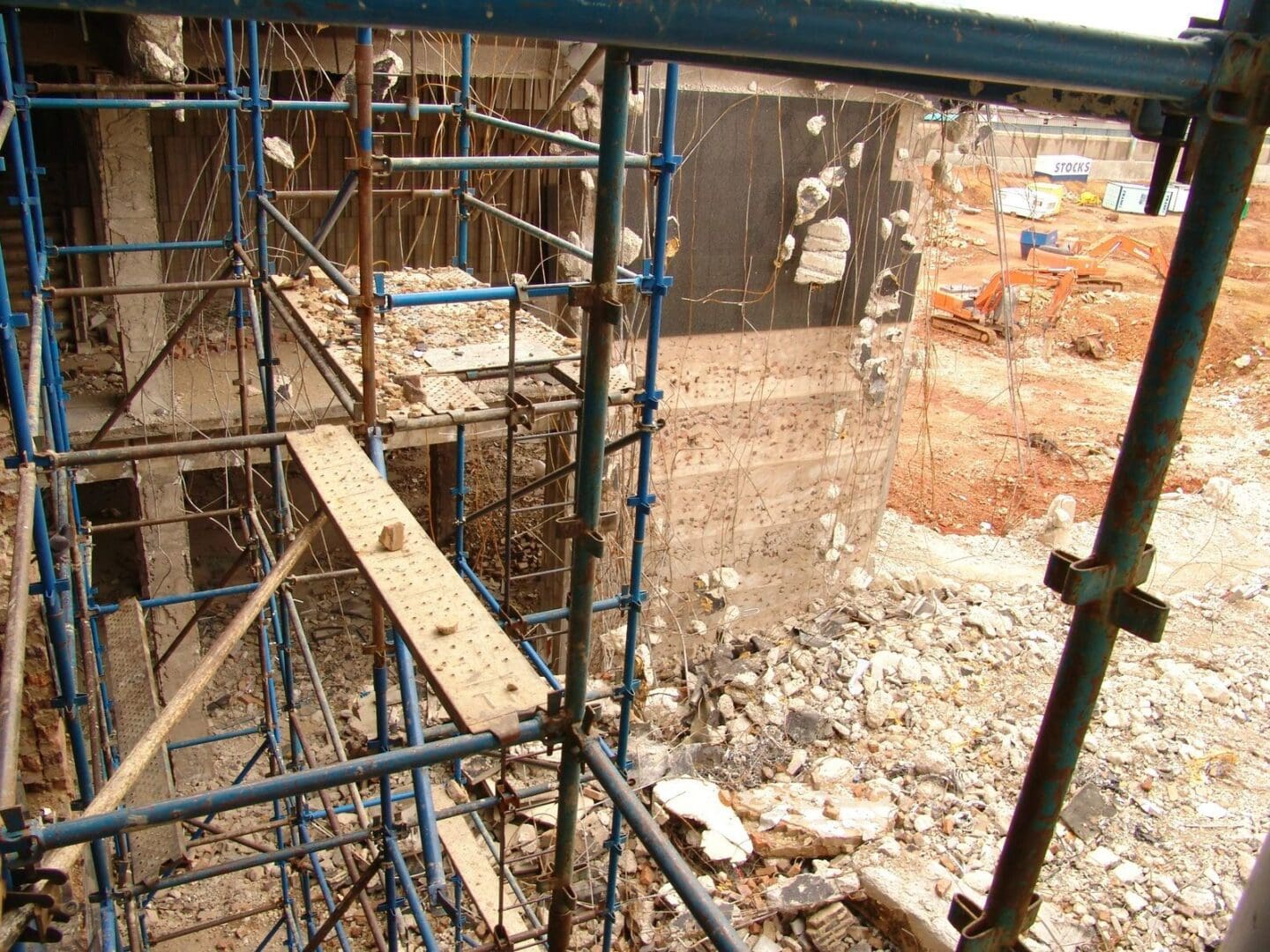 A building under construction with scaffolding and rubble.